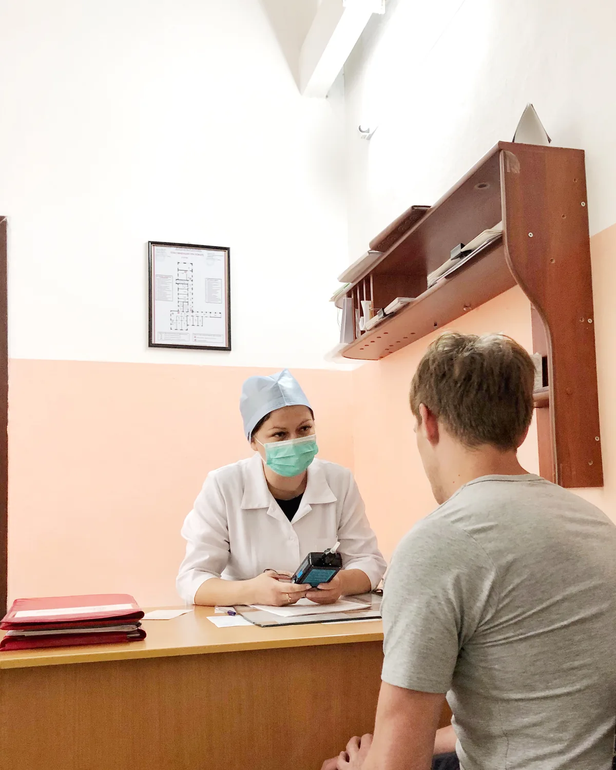 Медицинский работник беседует с пациентом в кабинете стационара